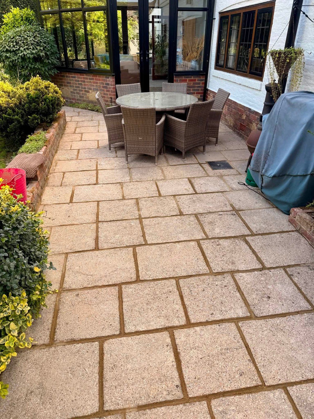 Sandstone patio with a raised planted border